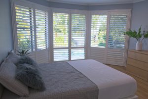 Luxury white indoor plantation shutters in bedroom