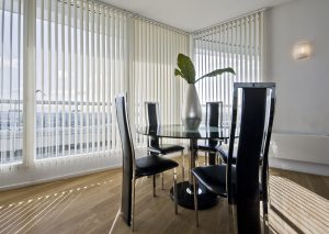 White vertical blinds in a modern dining room